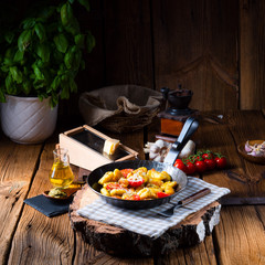 gnocchi baked with green pesto, cherry tomatoes and parmesan