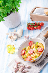 gnocchi baked with green pesto, cherry tomatoes and parmesan