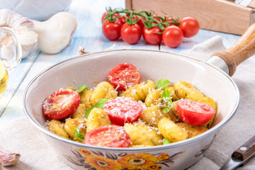 gnocchi baked with green pesto, cherry tomatoes and parmesan
