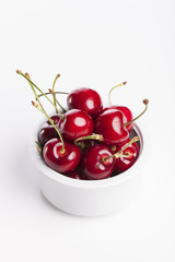 fresh red cherry on the white ceramic isolated white