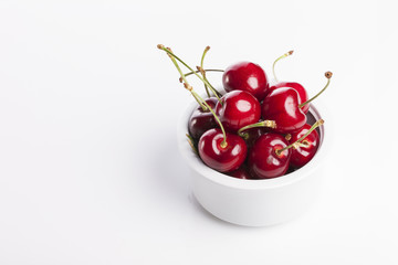 fresh red cherry on the white ceramic isolated white