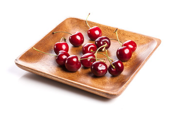 fresh red cherry on the wood tray isolated white