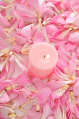 Obraz na płótnie Canvas Pile of pink tropical petals and candle