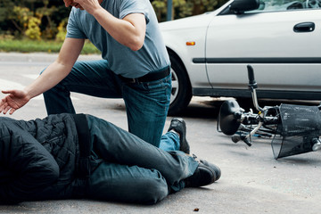 Car driver making emergency call after collision with a cyclist on the street