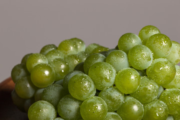 fresh green grapes on the wood table, grey background.
