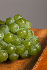 fresh green grapes on the wood table, grey background.