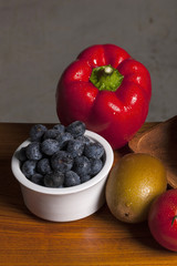 many variety fruits on the wood table, grey background