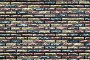 fragment of the wall with masonry of decorative bricks in different color schemes