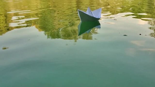 Paper boat floating on water at daytime