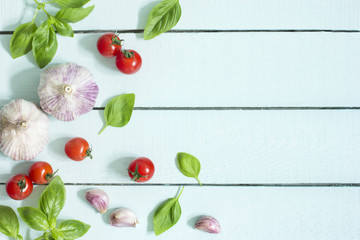 Naklejka na ściany i meble Tomatoes basil and garlic on blue wooden kitchen table 