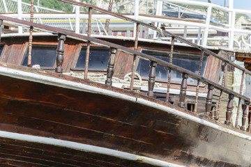 Front part of a vintage wooden boat, with curve and wooden hand rail.