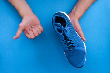 Hands holding a pair of new fitness sport sneakers. Buy a new shoes. Choosing of sneakers for...