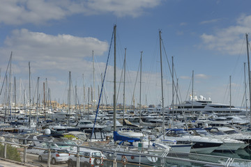 small sailing boats in the port of the Spanish city of Palma de Mallorca on the blue sky background