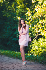 Full length portrait of a young beautiful caucasian woman in pink dress, long hair and casual makeup