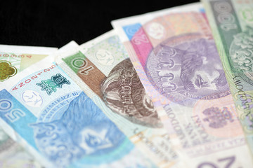 Obraz na płótnie Canvas Several banknotes of Polish zloty on a dark background close up