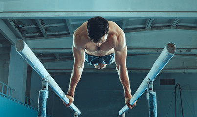 The sportsman performing difficult gymnastic exercise at gym. The sport, exercise, gymnast, health, training, athlete concept. Caucasian fit model © master1305