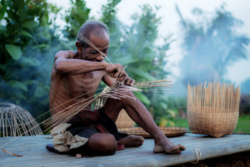 Old man are weaving in field.