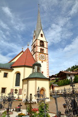 Fototapeta na wymiar The Catholic Church of Santa Cristina with tombs in the foreground, Val Gardena, Dolomites, Italy