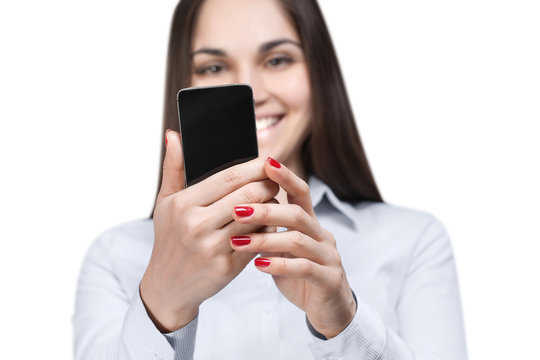 Young woman reading a message and smiling, isolated on white background