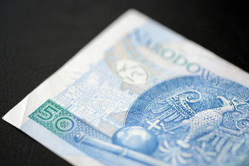 Naklejka premium Fifty Polish zlotys on a dark background close up 