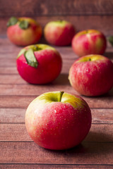 Fresh red apples with green leaves on a Dark wooden background.