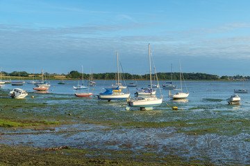 Fototapeta na wymiar Small boats and dinghies at low tide, near Dell Quay, Chichester Harbour, England, UK.