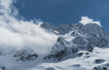 Obraz premium Peak in the italian alps covered by clouds.