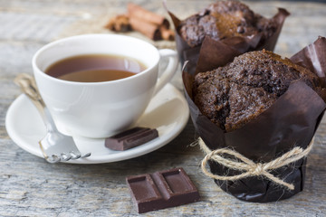Chocolate muffin and a Cup of coffee on a wooden background.