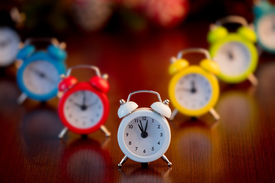 group of color alarm clocks on wooden background