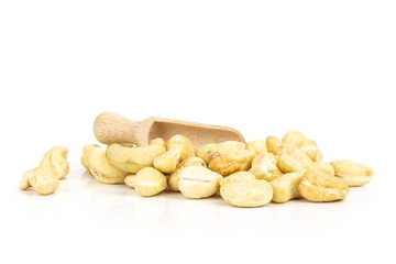 Lot of whole raw cashew nut with wooden scoop isolated on white background