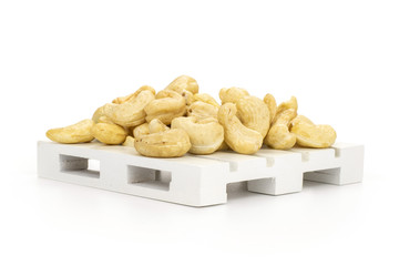 Lot of whole raw cashew nut on white pallet isolated on white background