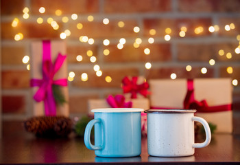 two cups of hot drinks on background with fairy lights in bokeh. Christmas Holiday season