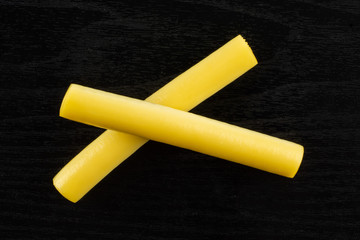 Group of two whole smoked slovak string cheese stick flatlay on black wood
