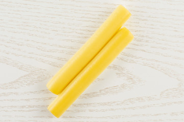 Group of two whole smoked slovak string cheese stick flatlay on grey wood