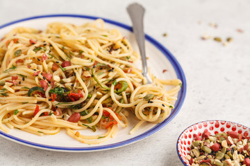 Healthy vegan pasta with zucchini, tomatoes and nuts.