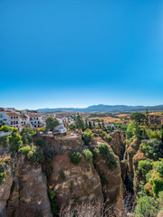 Fototapeta na wymiar Views of the houses built on the edge of the cliff, in the ancient city of Ronda, Spain