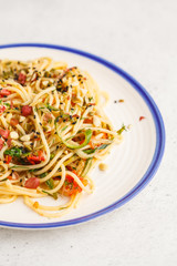 Healthy vegan pasta with zucchini, tomatoes and nuts.