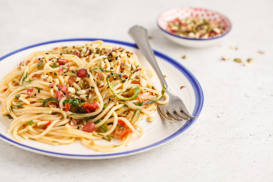 Healthy vegan pasta with zucchini, tomatoes and nuts.