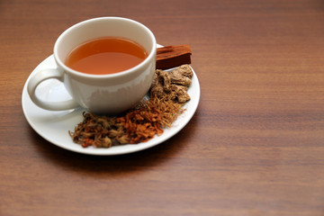 Brewed healthy herbal tea on a wooden background with all dry herbs ingredients. Herbal teas beverage for chinese or thai traditional alternative medicine therapy. 