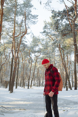 Tourist standing alone outdoor, orange cap and red plaid shirt, jacket. Travel lifestyle and emotions concept. Film effects colors. Wanderlust, hiking. Winter holiday. Christmas.