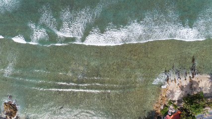 Tropical sea with wave crashing on beach aerial view drone shot.