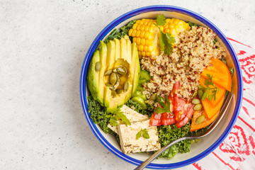 Vegan healthy rainbow salad, buddha bowl with quinoa, tofu, avocado and kale, copy space. Healthy clean eating concept.