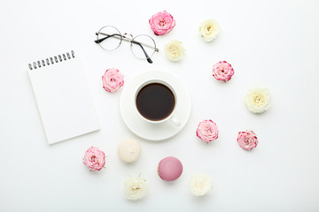 Fototapeta na wymiar Rose flowers with cup of coffee and macarons on white background