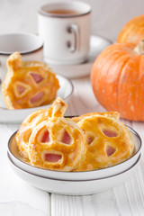 Halloween pumpkin buns with ham and cheese for Breakfast for kids in plate. Light wooden background
