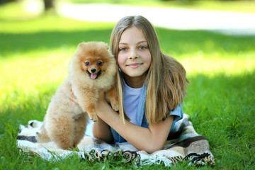Young girl with pomeranian dog in the park