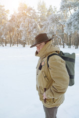 Backpackers. Man with backpack hiking in forest. Cold weather, snow on trees. Winter trekking. Film effects colors. Wanderlust, hiking. Winter holiday. Christmas.