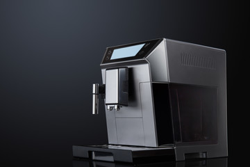 Coffee machine with flying coffee beans across it on dark background. Concept studio shooting. High speed freezing photo