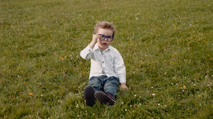 child in glasses on the grass