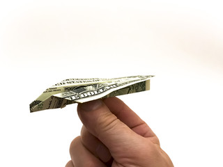 Hand holding a paper airplane from the dollar on a white background