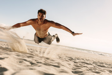 Man doing fitness exercise in beach sand